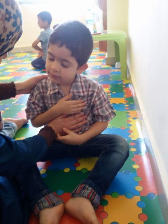 A boy with his hand on his heart, guided by a counselor